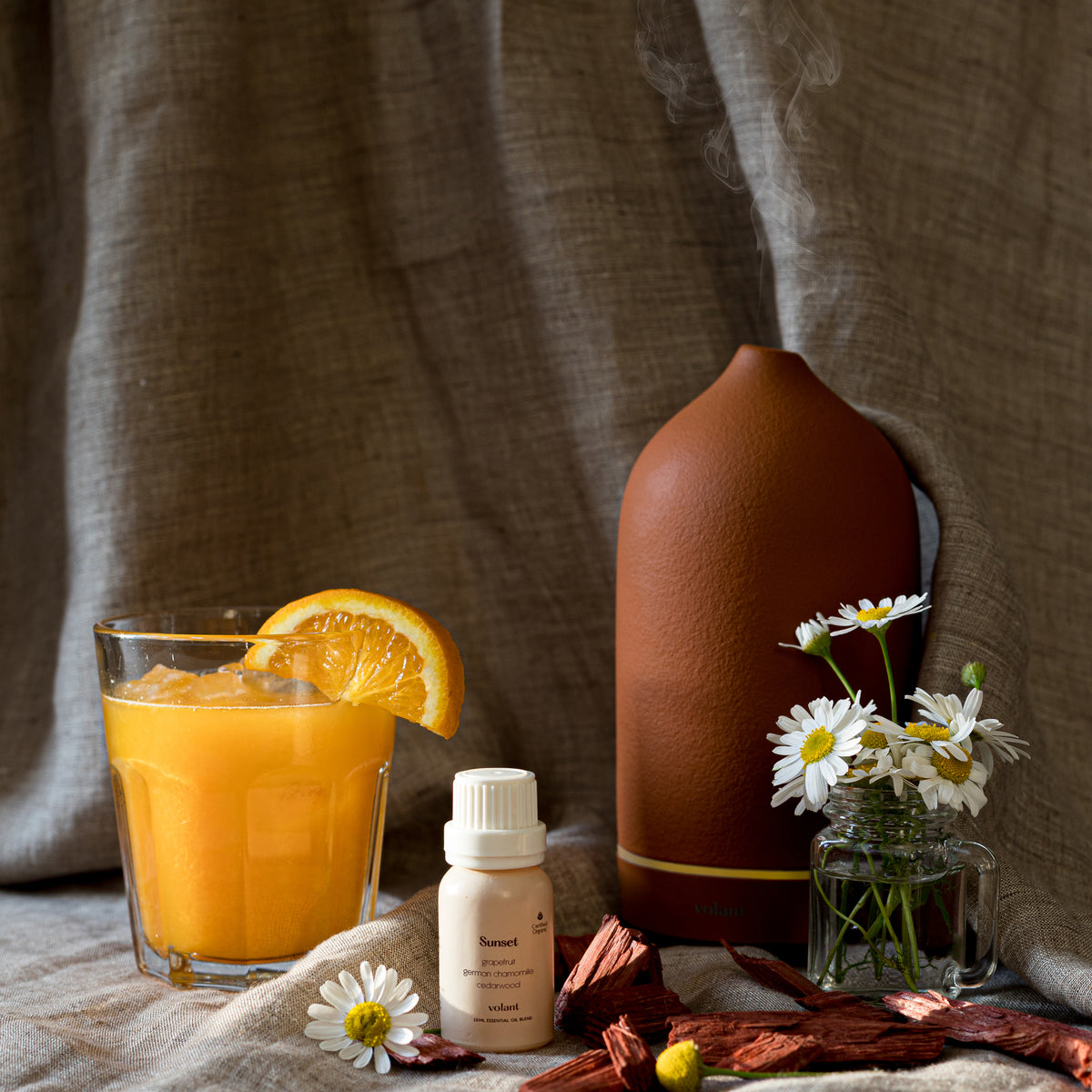 Volant Sunset flaska med eterisk oljeblandning och lerdiffusor. Den är gjord av ren cederträ, tysk kamomill och grapefrukt och är inspirerad av drömmar, solnedgångar och uppfriskande vindar. 